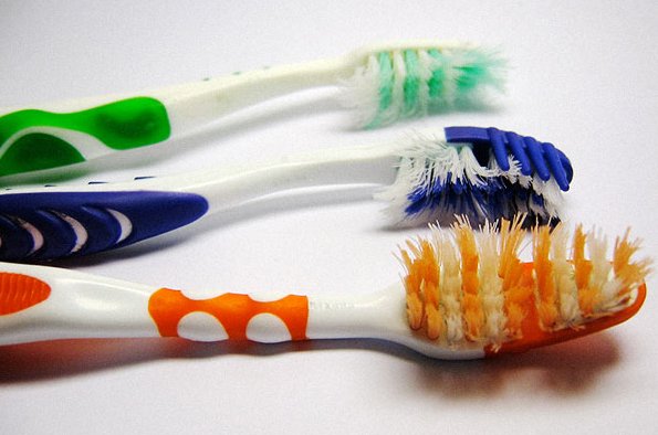 três tipos de escova de dentes, nova e antigas