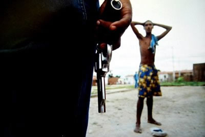 pessoa armada diante de um jovem negro