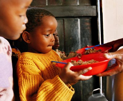 crianças recebendo prato de comida